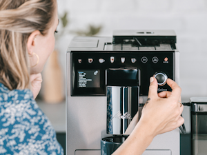 Komfortable Kaffevielfalt_21.png – Melitta® Lifestyle – Woman operates coffee machine within kitchen setting